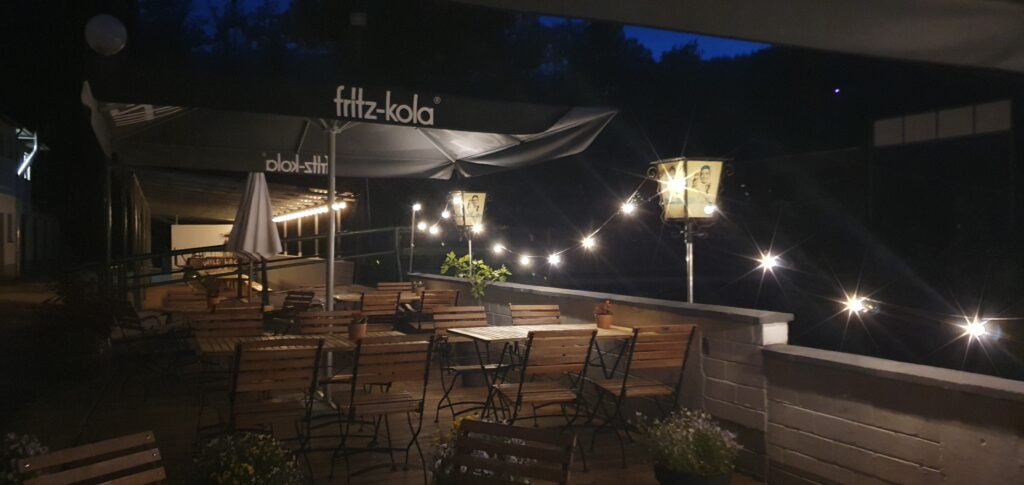 Camping Eifel. Wildbach Camping Hellenthal-Eifel 2026. Neuigkeiten für Camper 7 Nachtansicht Außensitzplätze Cafe Luchs bei Wildbach Camping