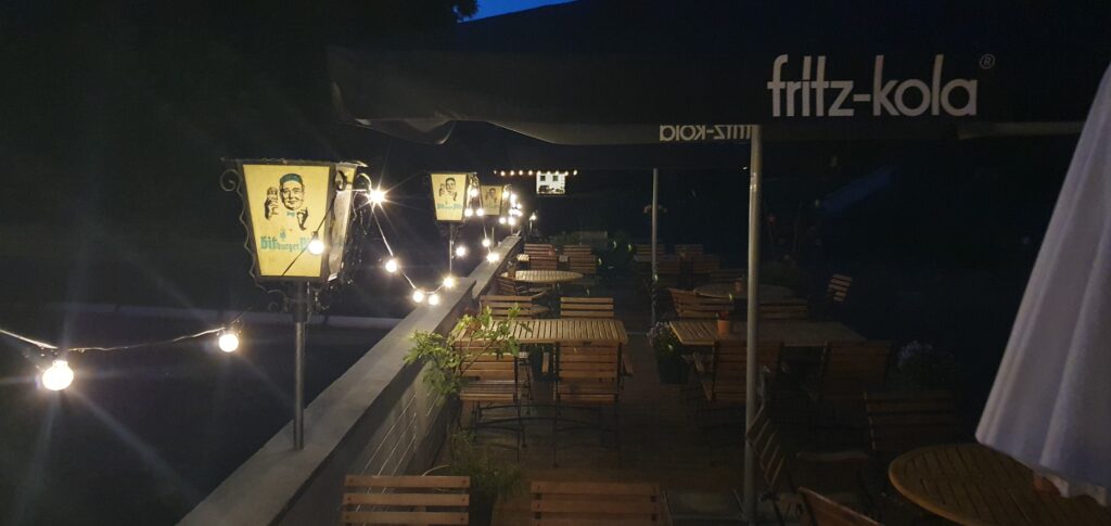 Camping Eifel. Wildbach Camping Hellenthal-Eifel 2026. Neuigkeiten für Camper 6 Sitzplätze Cafe Luchs am Bach bei Nacht